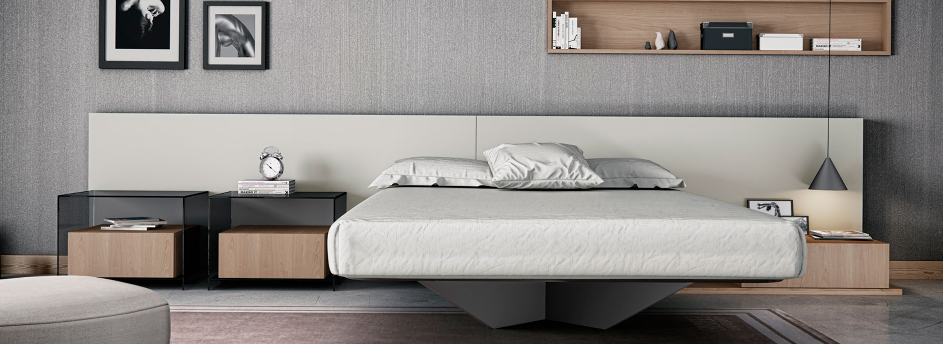 suite de la marca emede con cama en voladizo, soportada por un pieza central de color gris. Cabecero de cama en color beige y mesas de noche en color madera.