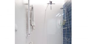 Vista de la ducha con acabados de paredes blancas y azulejos azules