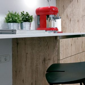 Reforma de cocina que combina el mármol blanco con el mobiliario en textura y color madera diseñada por Vibel Estudi
