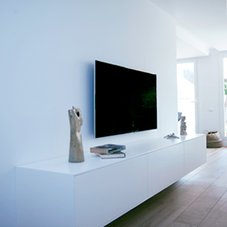 Interiorismo de vivienda en color blanco con suelo de parquet y mobiliario en negro diseñado por Vibel Estudi